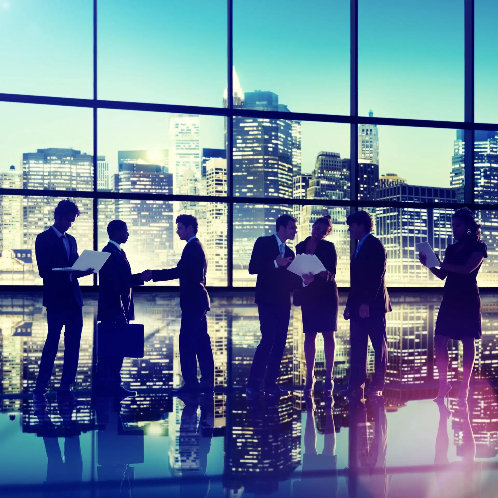 business people in front of large window with city skyline in background