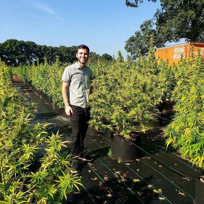 photo of Christian Dobson - owner of Piedmont Green CBD - standing in a hemp field