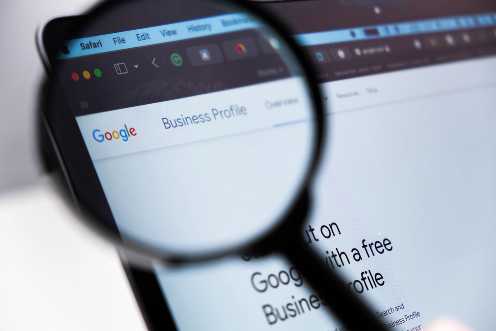 magnifying glass over laptop with Google Business Profile home screen