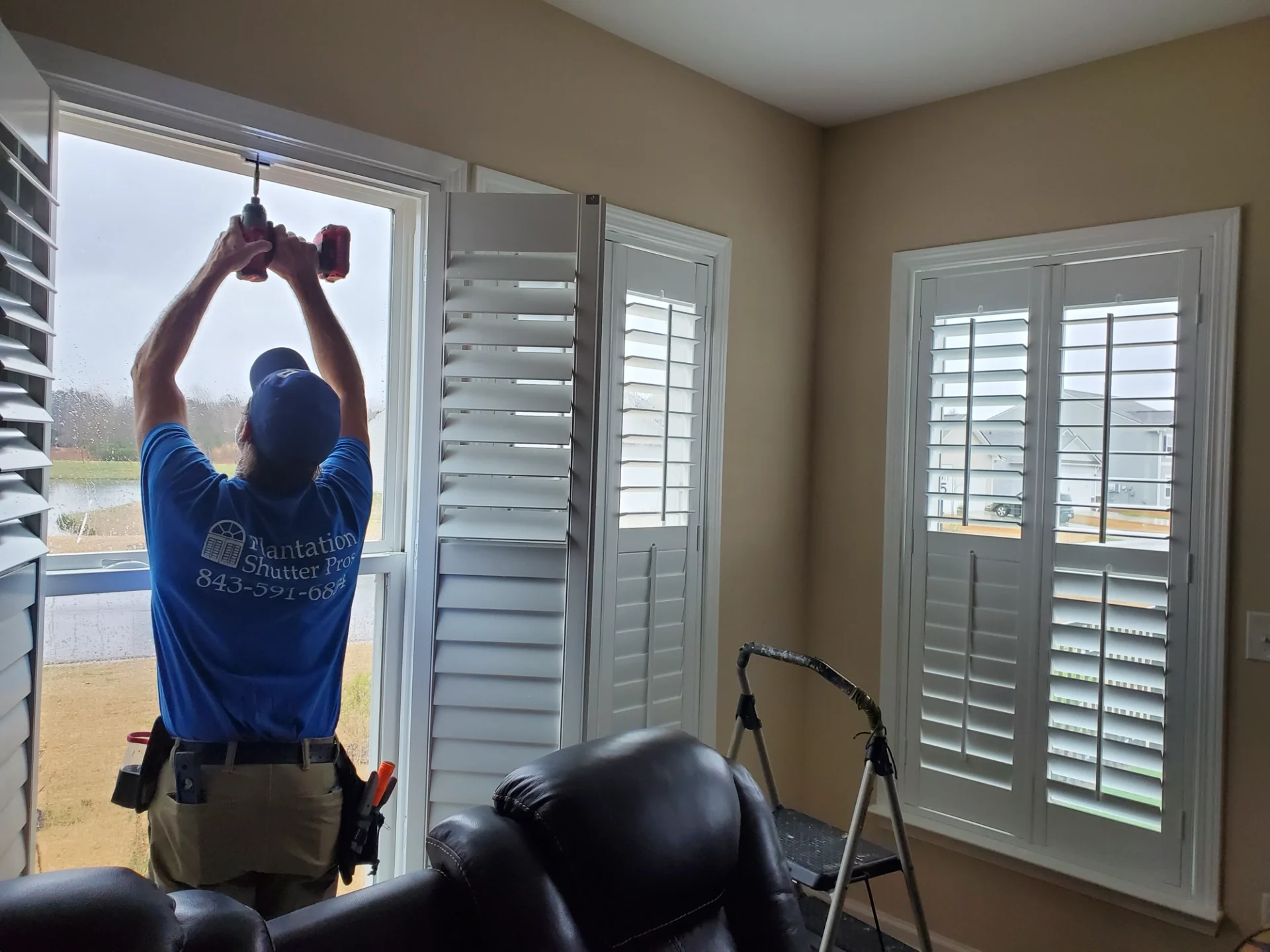 employee installing shutters