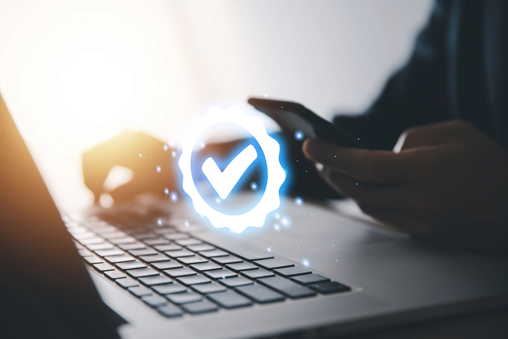 Businessman using a laptop showing digital technology icon symbol with a check mark.
